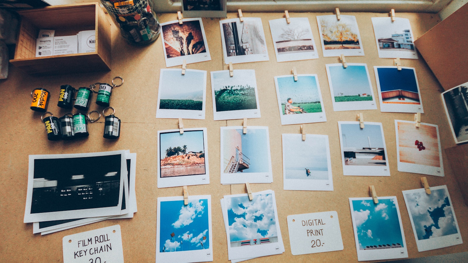 Stack of assorted printed photographs spread across a wooden table — the analog version of an Immich library.
