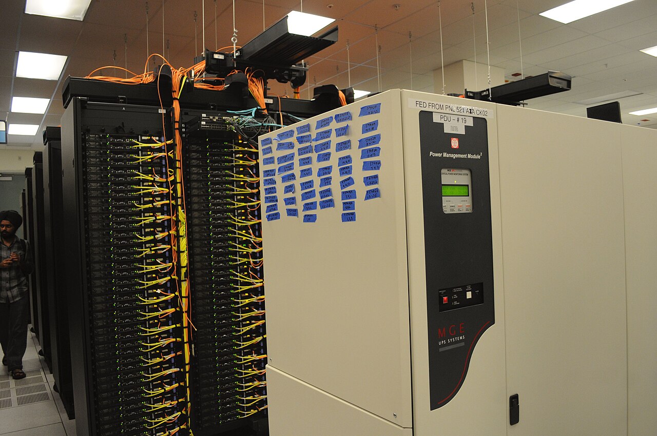 Server racks with dense network cabling in a data center — the kind of box a DNS tunnel endpoint runs on.